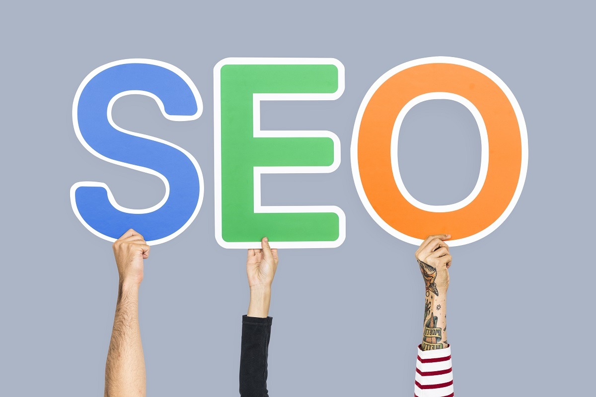 Hands holding up colorful letters forming the abbreviation SEO